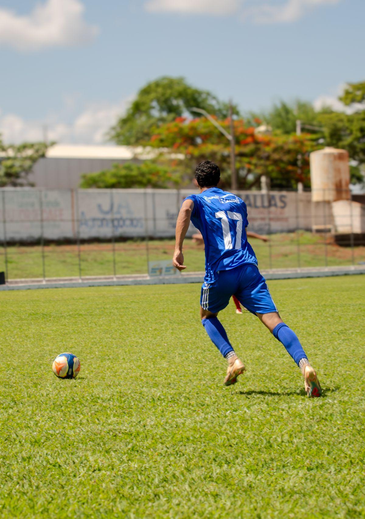 Football player sprinting toward the ball on the pitch